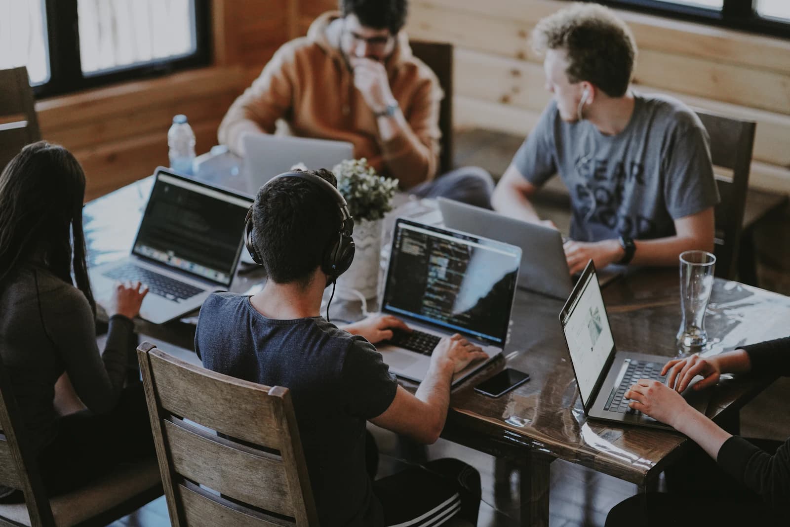 The team working together around a table with laptops
